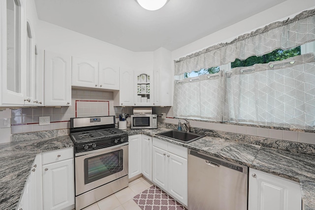 6851 Clyde St, Forest Hills, NY 11375 - kitchen featuring stainless steel appliances, white cabinets, backsplash, and dark stone countertops