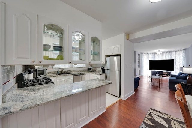 6851 Clyde St, Forest Hills, NY 11375 - kitchen featuring stainless steel appliances, glass insert cabinets, white cabinets, open floor plan, and light wood-style floors