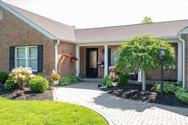 31-33 Dunlop Ct, Commack, NY 11725 - view of exterior entry featuring brick siding, roof with shingles, and covered porch