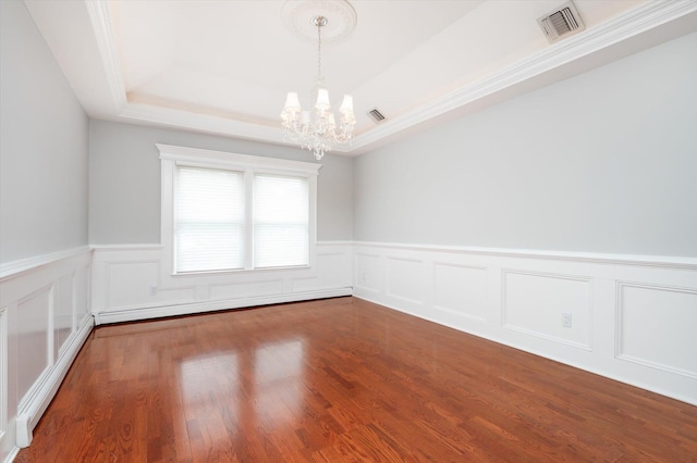 31-33 Dunlop Ct, Commack, NY 11725 - empty room with a chandelier, a raised ceiling, baseboard heating, a wainscoted wall, and wood finished floors