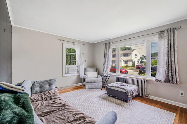 4 Jones St N, Patchogue, NY 11772 - bedroom featuring radiator heating unit, multiple windows, wood finished floors, cooling unit, and ornamental molding