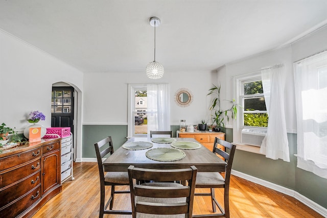 4 Jones St N, Patchogue, NY 11772 - dining space with arched walkways, light wood-style floors, cooling unit, and crown molding