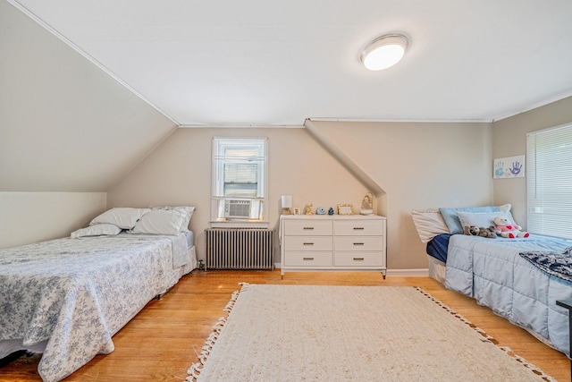 4 Jones St N, Patchogue, NY 11772 - bedroom featuring radiator, light wood-type flooring, ornamental molding, vaulted ceiling, and cooling unit