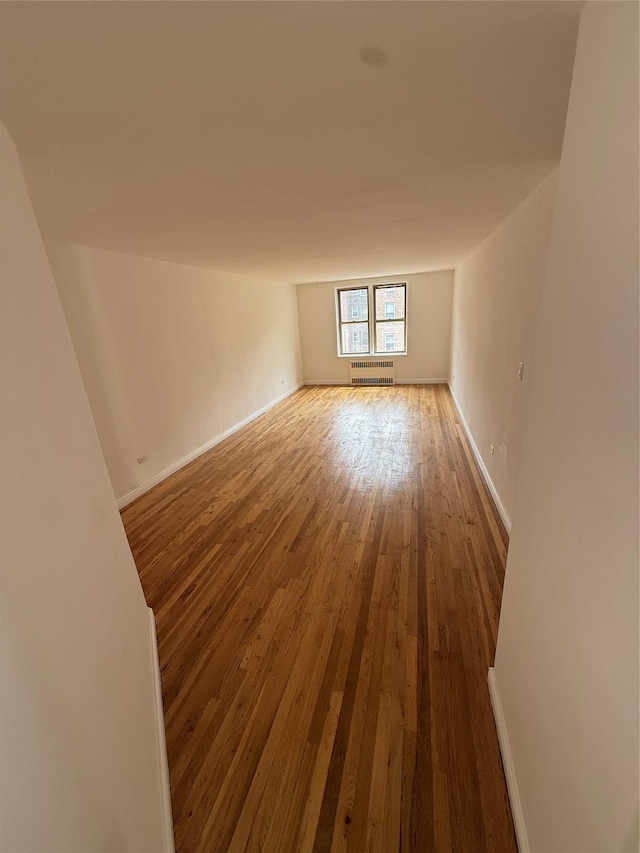 67-25 Clyde St Unit 5D, Forest Hills, NY 11375 - unfurnished room featuring an AC wall unit and hardwood / wood-style flooring