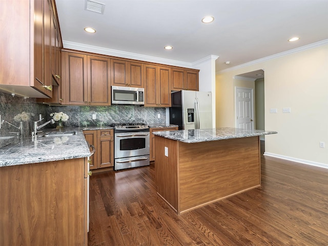 195 Pond View Dr Unit Ca0208, Port Washington, NY 11050 - kitchen with stainless steel appliances, a kitchen island, dark wood-type flooring, crown molding, and light stone counters