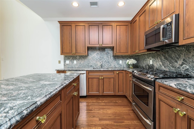 195 Pond View Dr Unit Ca0208, Port Washington, NY 11050 - kitchen with stainless steel appliances, dark wood-style floors, dark stone countertops, decorative backsplash, and recessed lighting