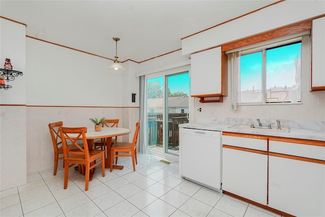 21 Carol Pl, Staten Island, NY 10303 - kitchen featuring white dishwasher, light countertops, white cabinetry, a wainscoted wall, and decorative light fixtures