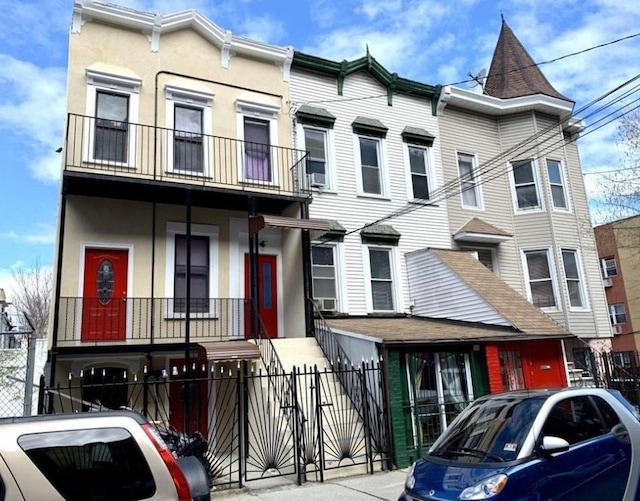 2301 Bathgate Ave, Bronx, NY 10458 - townhome / multi-family property with a fenced front yard, a gate, and stucco siding