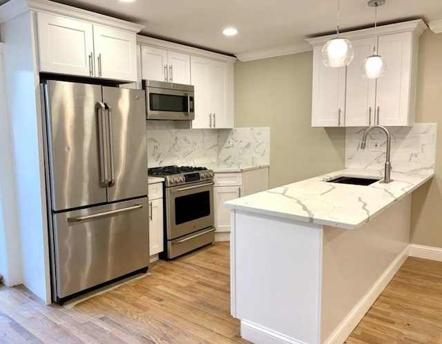 2301 Bathgate Ave, Bronx, NY 10458 - kitchen featuring stainless steel appliances, a peninsula, light wood finished floors, white cabinetry, and recessed lighting