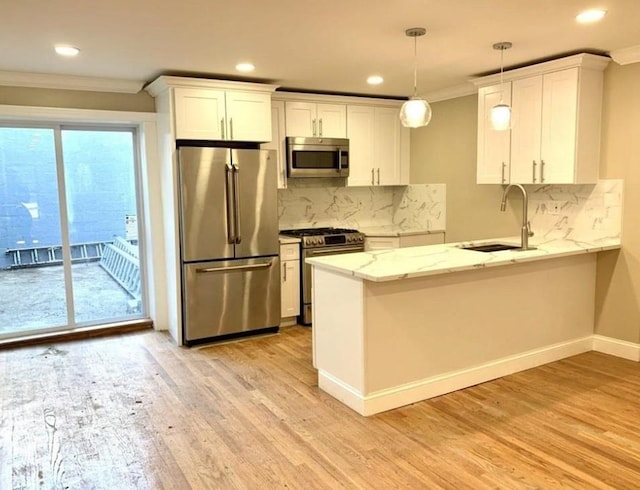 2301 Bathgate Ave, Bronx, NY 10458 - kitchen featuring stainless steel appliances, ornamental molding, white cabinets, a peninsula, and light wood finished floors