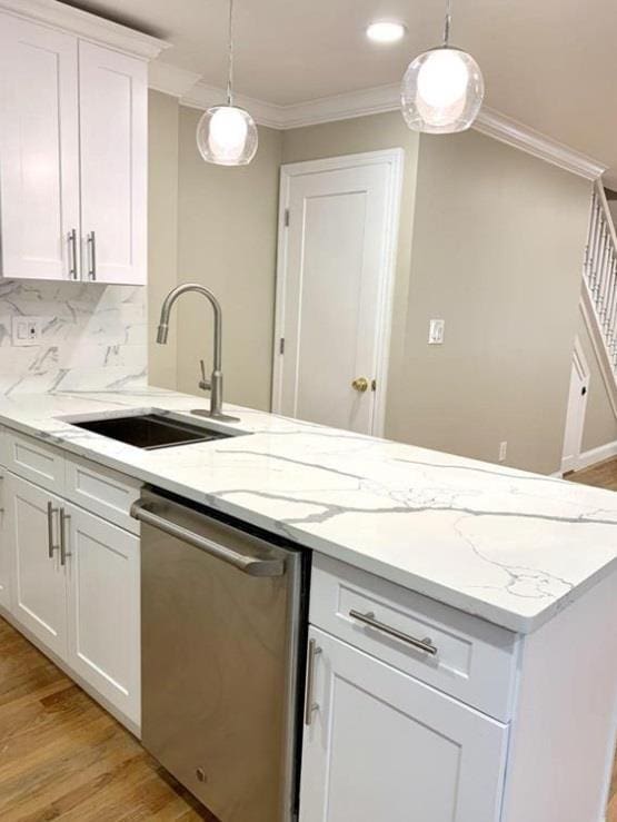 2301 Bathgate Ave, Bronx, NY 10458 - kitchen with stainless steel dishwasher, light wood finished floors, ornamental molding, white cabinetry, and tasteful backsplash