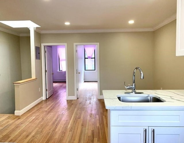 2301 Bathgate Ave, Bronx, NY 10458 - kitchen featuring light wood-style floors, light stone countertops, white cabinetry, ornamental molding, and recessed lighting