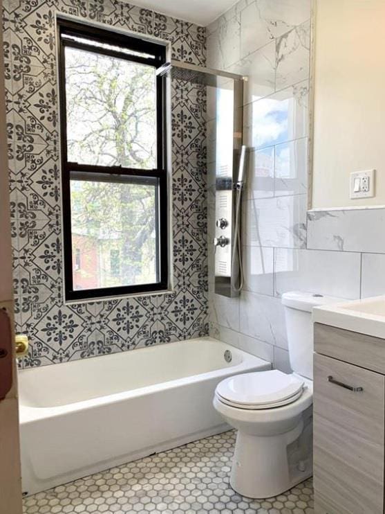 2301 Bathgate Ave, Bronx, NY 10458 - bathroom with tile walls, vanity, tile patterned floors, and tub / shower combination