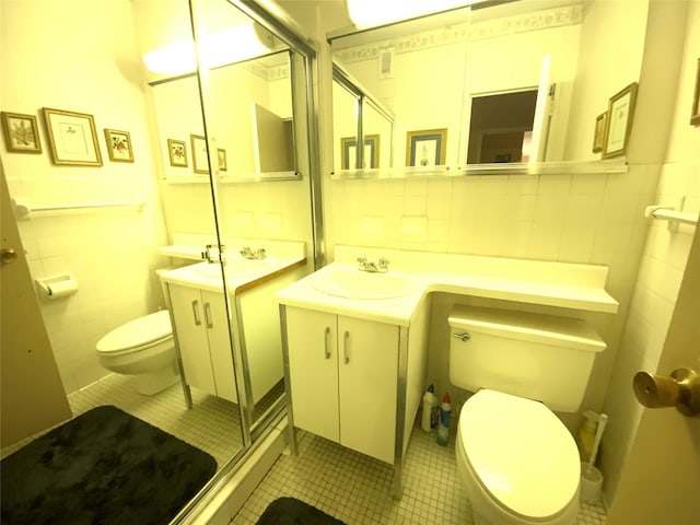27110 Grand Central Pkwy Unit 5A, Floral Park, NY 11005 - bathroom featuring tile walls, tile patterned flooring, two vanities, a shower stall, and wainscoting