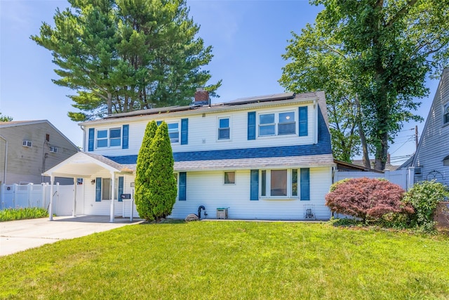 4 Wagon Ln, Levittown, NY 11756 - view of front of house with roof mounted solar panels, concrete driveway, a chimney, and a shingled roof