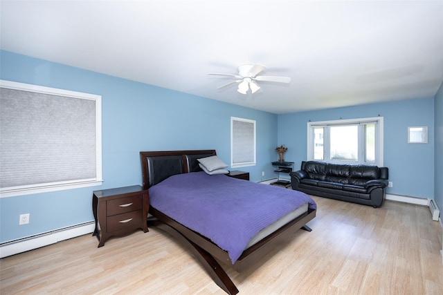 4 Wagon Ln, Levittown, NY 11756 - bedroom with light wood-type flooring, a baseboard radiator, a baseboard heating unit, and ceiling fan