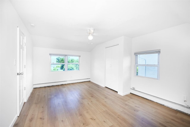4 Wagon Ln, Levittown, NY 11756 - unfurnished bedroom featuring baseboard heating, light wood finished floors, a ceiling fan, and a closet
