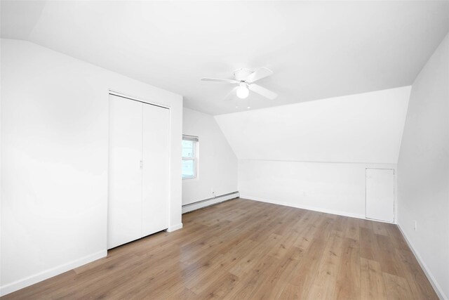 4 Wagon Ln, Levittown, NY 11756 - additional living space featuring baseboard heating, lofted ceiling, a ceiling fan, and light wood-type flooring