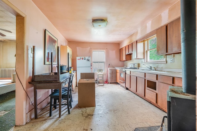 50 Maple St, Catskill, NY 12414 - kitchen featuring stainless steel gas stove, freestanding refrigerator, light countertops, ceiling fan, and brown cabinets