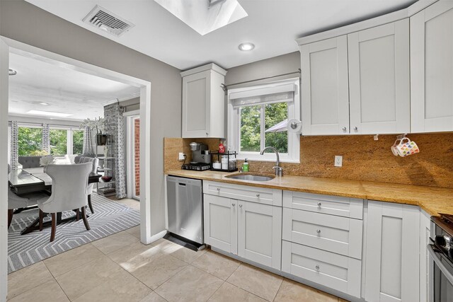 46 Alta Pl, Yonkers, NY 10710 - kitchen featuring stainless steel dishwasher, tasteful backsplash, a skylight, and light countertops
