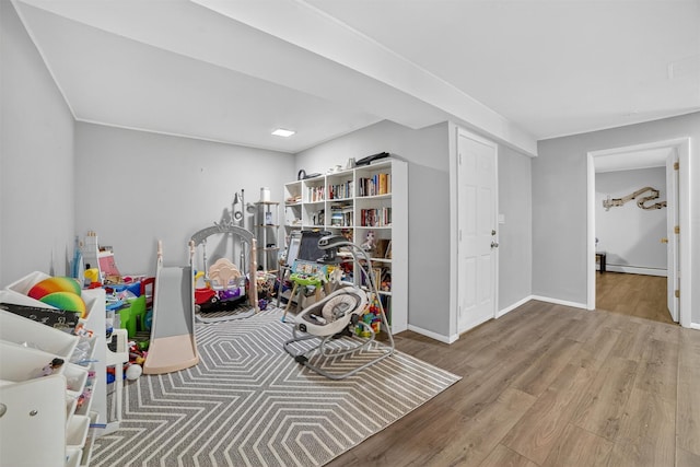 46 Alta Pl, Yonkers, NY 10710 - playroom with wood finished floors and a baseboard heating unit