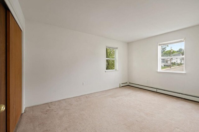 180 Depew Ave, Nyack, NY 10960 - unfurnished bedroom with multiple windows, light colored carpet, a baseboard radiator, and a closet