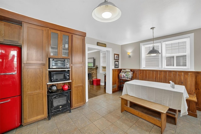 167 Hillview Ave, Yonkers, NY 10704 - kitchen with black microwave, wainscoting, brown cabinetry, refrigerator, and glass insert cabinets