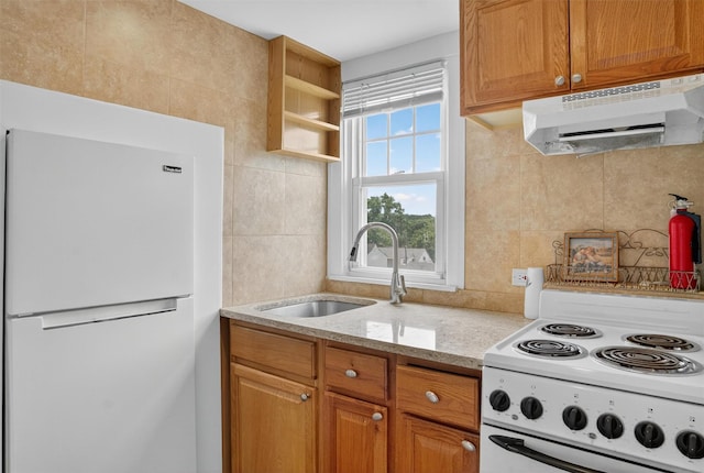 167 Hillview Ave, Yonkers, NY 10704 - kitchen with white appliances, under cabinet range hood, tasteful backsplash, light stone countertops, and brown cabinets