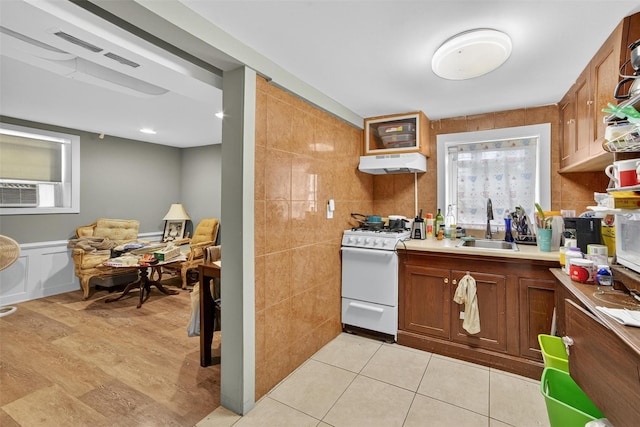 167 Hillview Ave, Yonkers, NY 10704 - kitchen featuring white gas range, under cabinet range hood, light countertops, and brown cabinetry