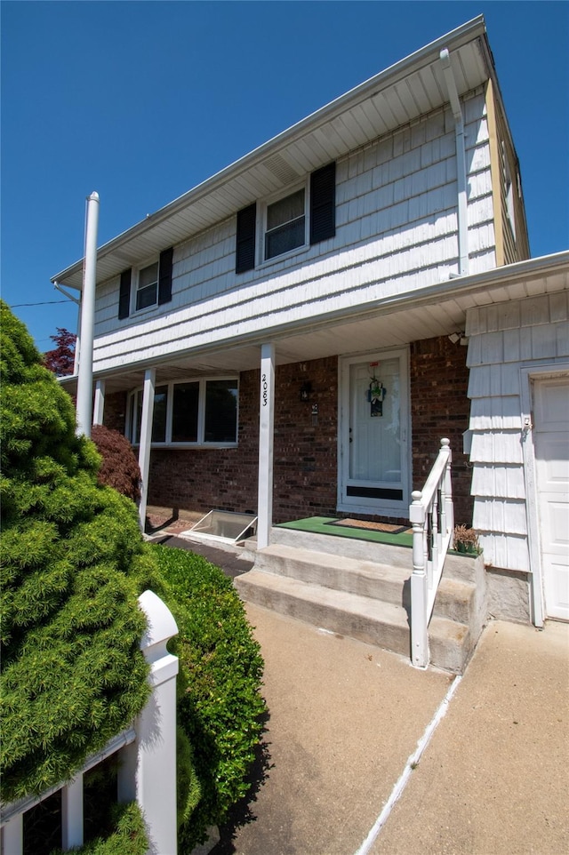 2083 Elm Pl, Merrick, NY 11566 - view of front facade featuring brick siding and covered porch