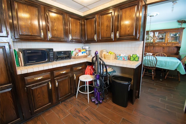 2083 Elm Pl, Merrick, NY 11566 - kitchen featuring black microwave, tile counters, tasteful backsplash, dark wood-type flooring, and dark brown cabinetry