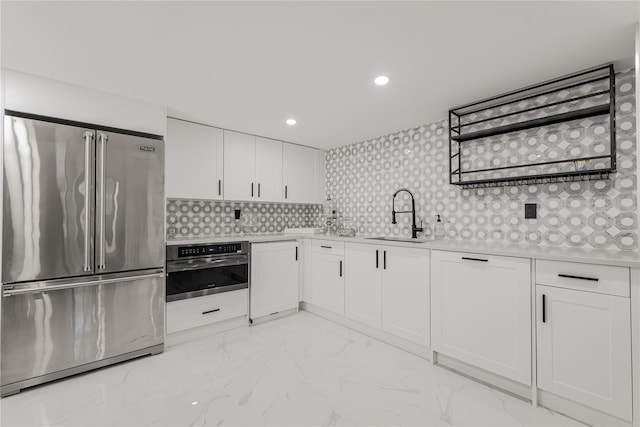 3 Fairview Ln, Glen Cove, NY 11542 - kitchen with appliances with stainless steel finishes, light countertops, white cabinetry, tasteful backsplash, and light marble finish floors