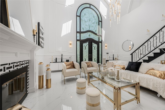 3 Fairview Ln, Glen Cove, NY 11542 - living area featuring a high ceiling, marble tiled flooring, stairway, a decorative wall, and a fireplace