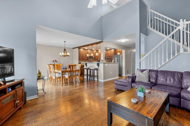 48 Sparrow Ridge Rd, Carmel, NY 10512 - living room with stairs, dark wood-type flooring, a towering ceiling, a chandelier, and a ceiling fan