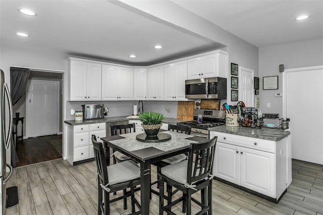 18 Seawane Rd, East Rockaway, NY 11518 - kitchen featuring stainless steel appliances, wood tiled floors, white cabinets, and recessed lighting