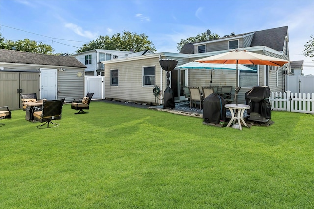 18 Seawane Rd, East Rockaway, NY 11518 - back of house featuring a fenced backyard, a fire pit, a storage unit, and a shingled roof