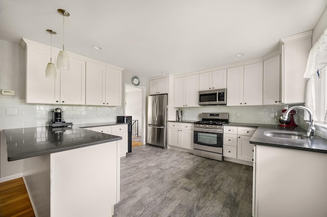 7 Frost Ln, Hartsdale, NY 10530 - kitchen with appliances with stainless steel finishes, dark countertops, a peninsula, decorative backsplash, and recessed lighting