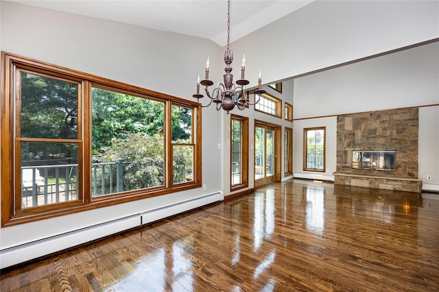 45 Mc Cue Ln, Babylon, NY 11702 - unfurnished living room featuring a baseboard heating unit, a chandelier, wood finished floors, high vaulted ceiling, and a stone fireplace