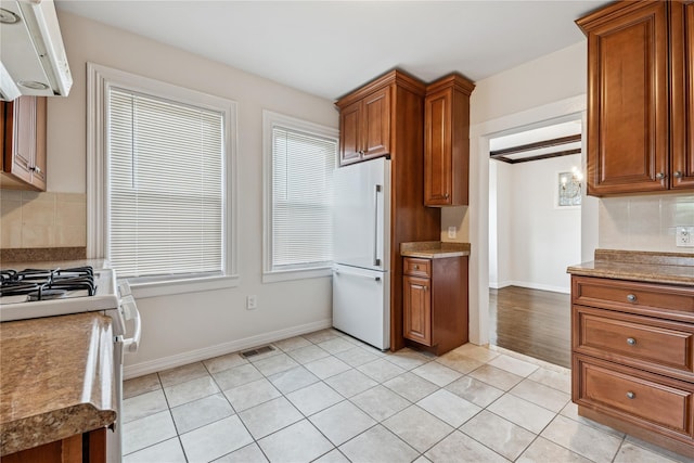 401 Ocean Ave, Malverne, NY 11565 - kitchen featuring white appliances, range hood, tasteful backsplash, and brown cabinets