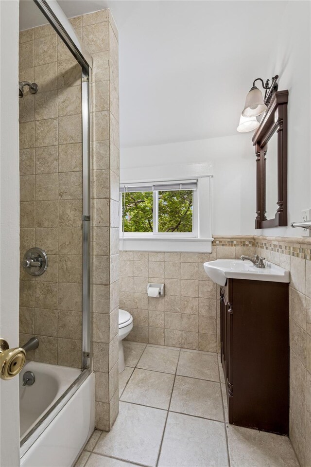 401 Ocean Ave, Malverne, NY 11565 - full bath featuring tile walls, vanity, tile patterned flooring, wainscoting, and bath / shower combo with glass door