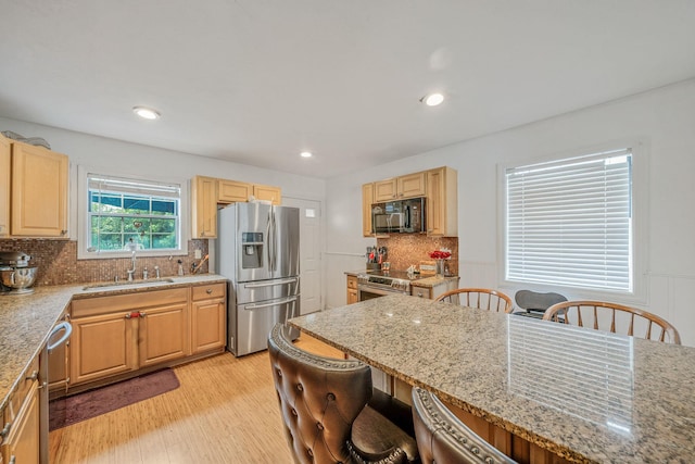 108A Union Ave, Lake Ronkonkoma, NY 11779 - kitchen with stainless steel appliances, a kitchen bar, light wood-style floors, decorative backsplash, and light stone counters