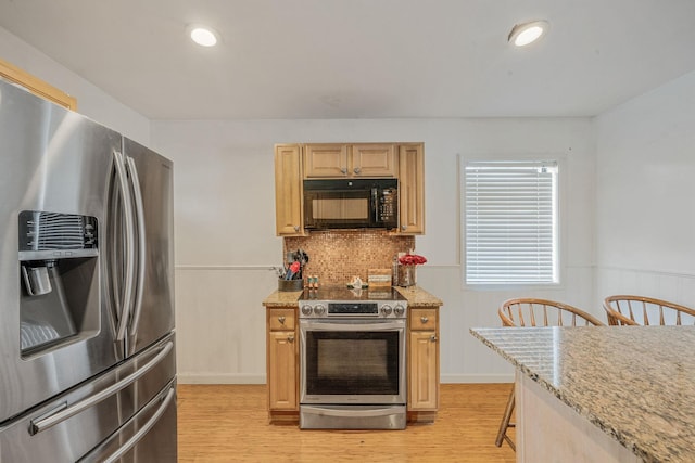 108A Union Ave, Lake Ronkonkoma, NY 11779 - kitchen with appliances with stainless steel finishes, light wood finished floors, light stone counters, backsplash, and wainscoting