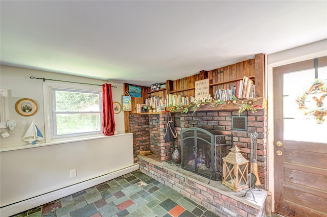 123 Lake St, Islip, NY 11751 - unfurnished living room featuring a baseboard heating unit, a brick fireplace, stone finish floors, and wooden walls