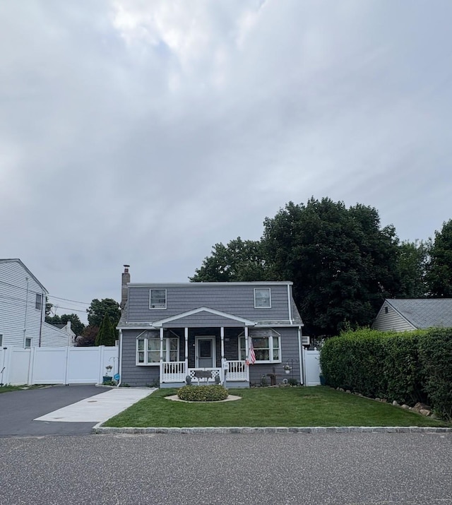 126 E 12th St, Huntington Station, NY 11746 - view of front of house with a porch, a chimney, and driveway