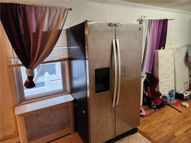 815 Swinton Ave, Bronx, NY 10465 - kitchen with stainless steel fridge, radiator heating unit, light tile patterned floors, and crown molding