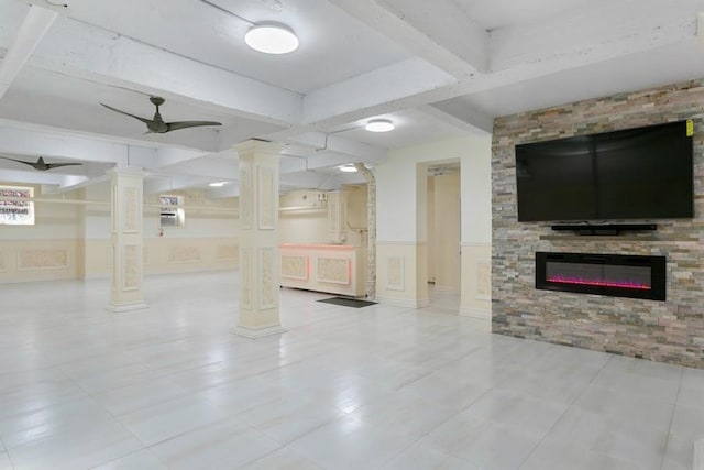 33-25 90th St Unit 3A, Jackson Heights, NY 11372 - unfurnished living room with ornate columns, beamed ceiling, wainscoting, a glass covered fireplace, and a ceiling fan