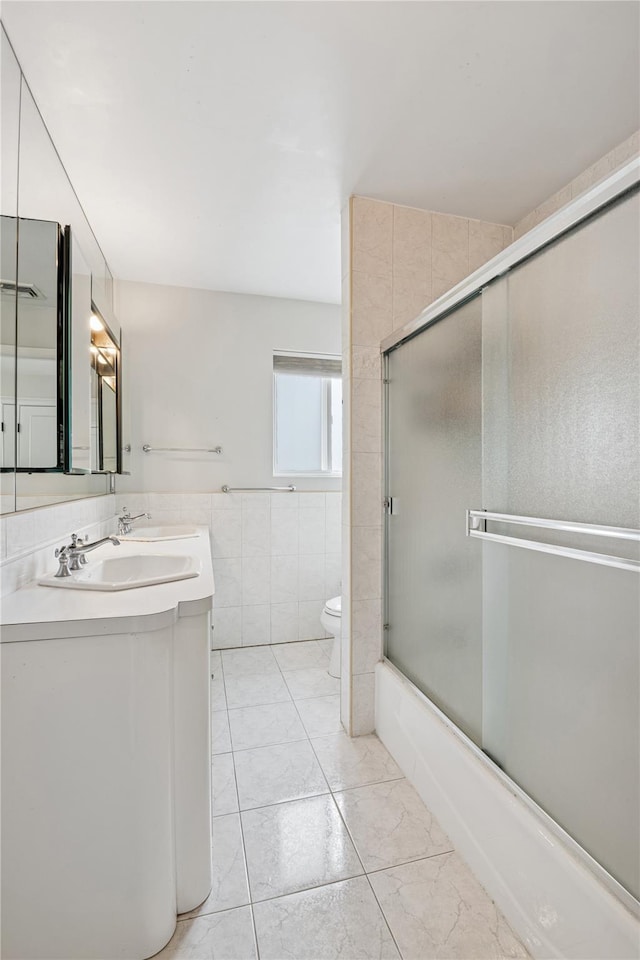230 W Beech St, Long Beach, NY 11561 - full bath featuring double vanity, tile walls, shower / bath combination with glass door, and marble look tiles