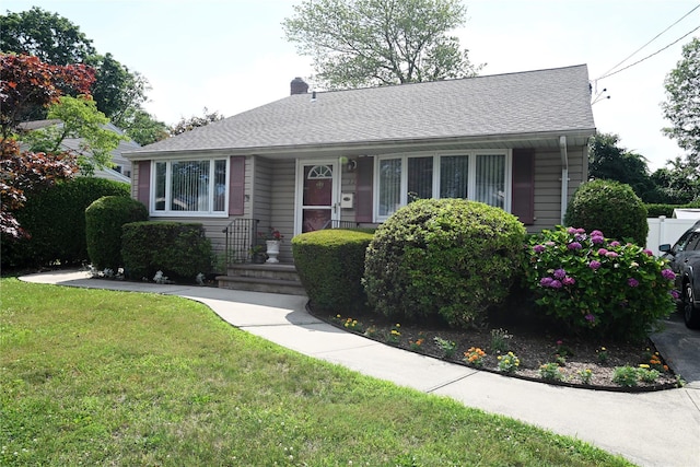 22 Victoria Rd, North Babylon, NY 11703 - view of front of home featuring a front lawn and a chimney