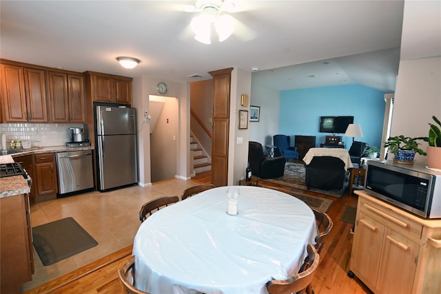22 Victoria Rd, North Babylon, NY 11703 - kitchen featuring appliances with stainless steel finishes, ceiling fan, backsplash, brown cabinetry, and open floor plan