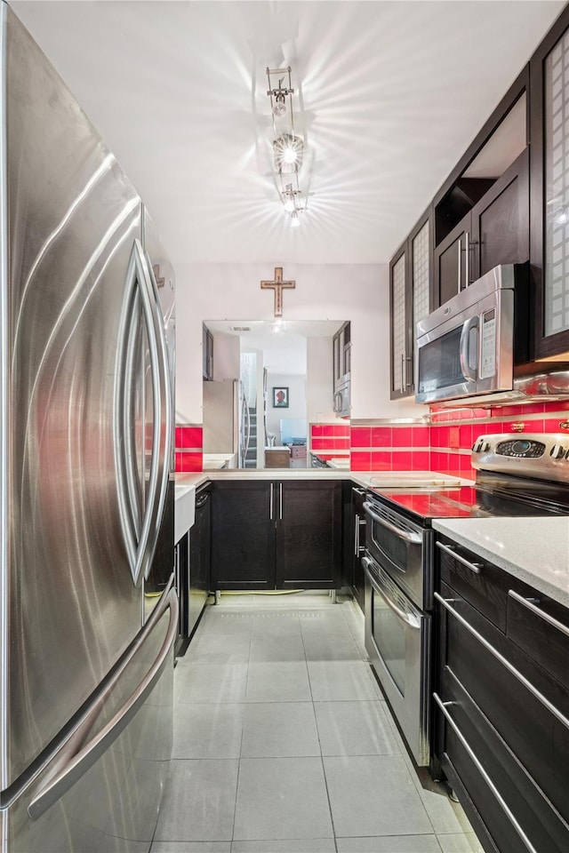 425 Shore Rd Unit 1A, Long Beach, NY 11561 - kitchen with appliances with stainless steel finishes, light countertops, light tile patterned floors, and tasteful backsplash